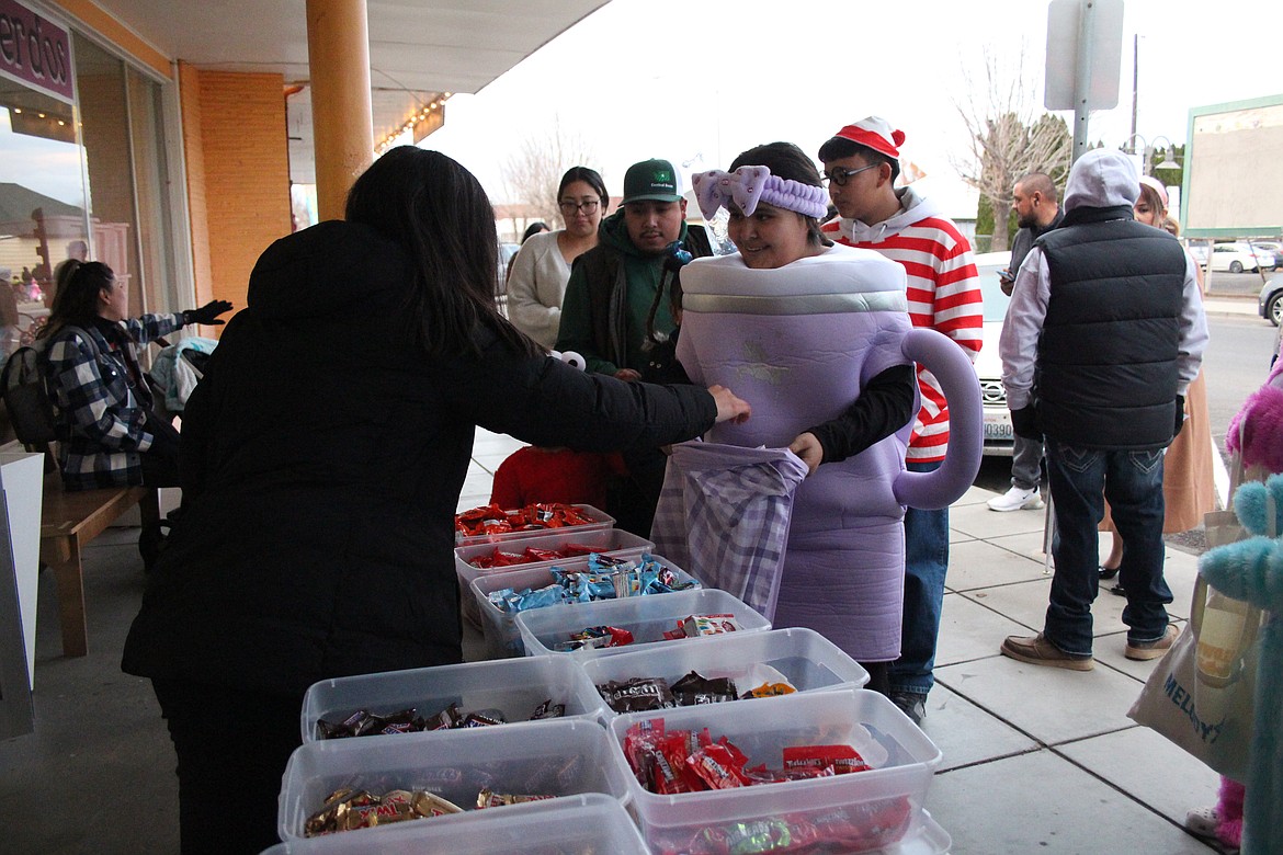 A purple coffee mug scores some candy on Halloween at Quincy’s Downtown Trick or Treat.