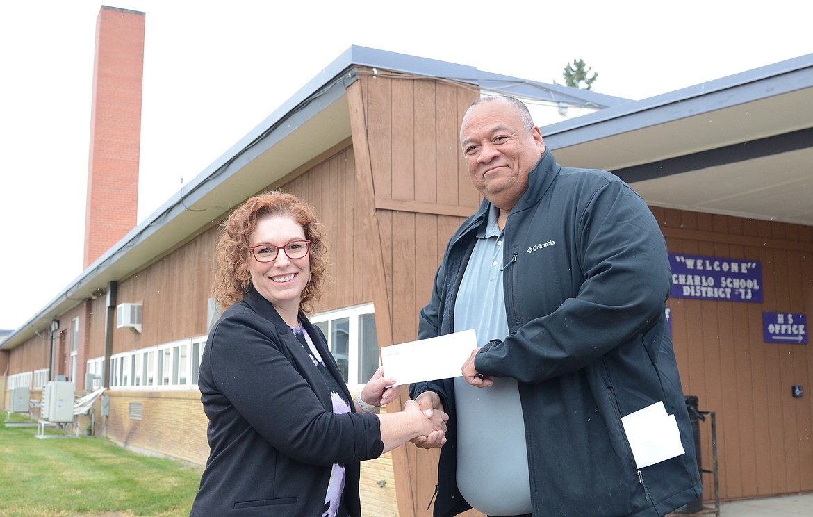 Charlo Superintendent Teresa Weems receives a $78,000 rebate check from Mission Valley Power General Manager Zachary Conko Camel. (Kristi Niemeyer/Leader)