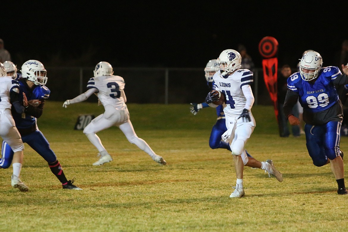 Lions sophomore Treyson Kast (4) evades Soap Lake defenders in the second quarter against Soap Lake on Friday. Kast scored on a six-yard run just before halftime to give the Lions a 20-14 lead.