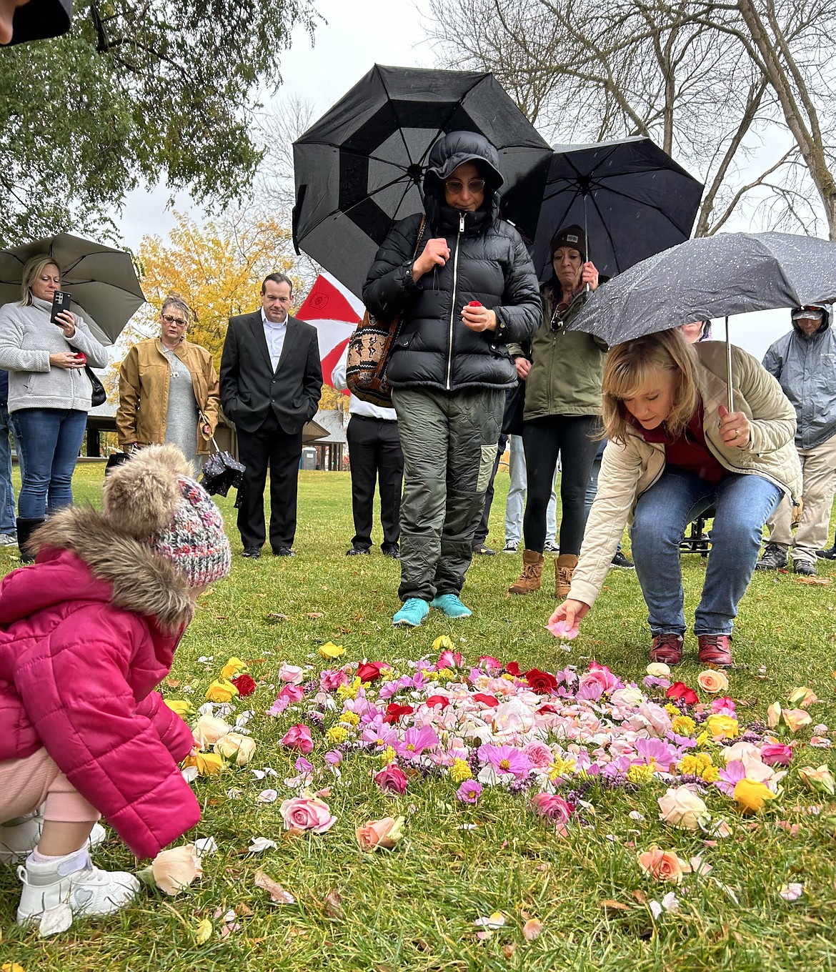 Friends and family place flowers at City Park in memory of Madison Mogen, Kaylee Goncalves and Xana Kernodle on Saturday.