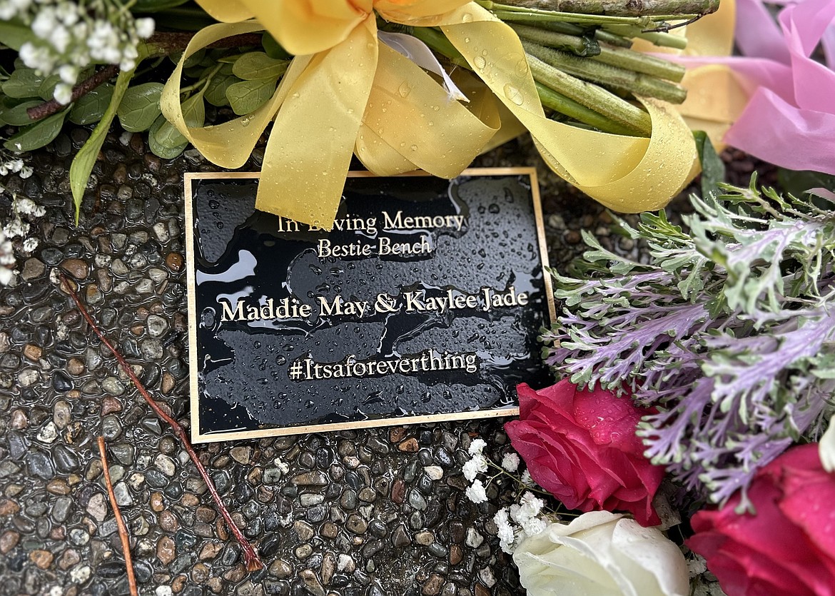 A plaque for Madison Mogen and Kaylee Goncalaves is decorated with flowers at City Park.