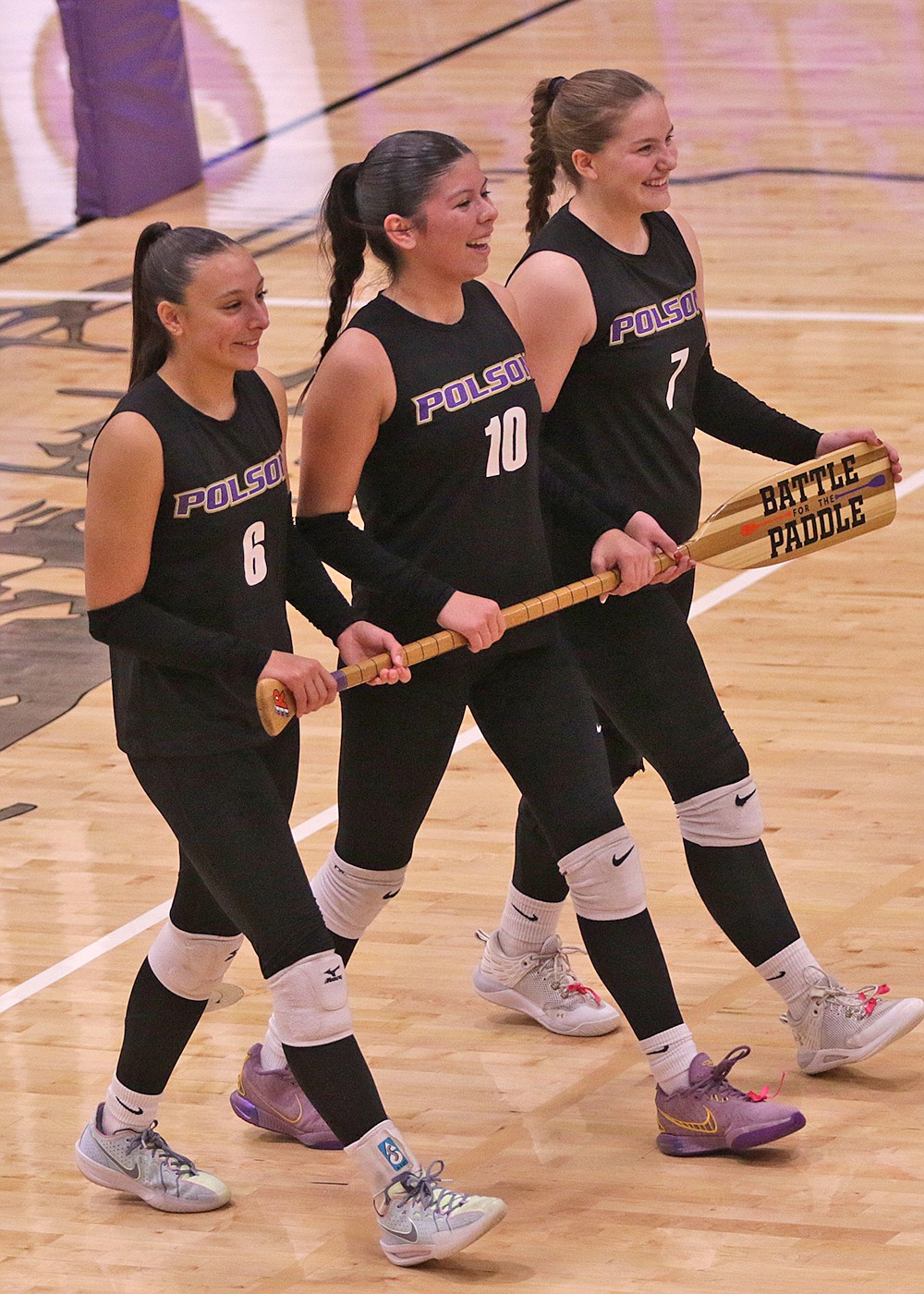 Trio of Polson seniors proudly reclaim the paddle they lost to county rival Ronan last year after last Thursday's triumph. (Bob Gunderson photo)