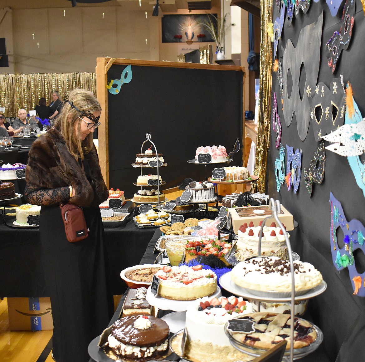 Karen Moore checks out the desserts arrayed for a dessert dash at St. Rose of Lima Catholic School’s fundraiser auction and banquet Saturday.