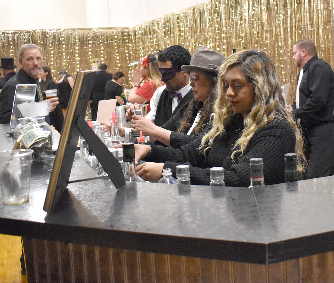 From left: Jacob Green, Michelle Brown and Jacky Mendez keep busy pouring drinks at the St. Rose of Lima Catholic School fundraiser Saturday.