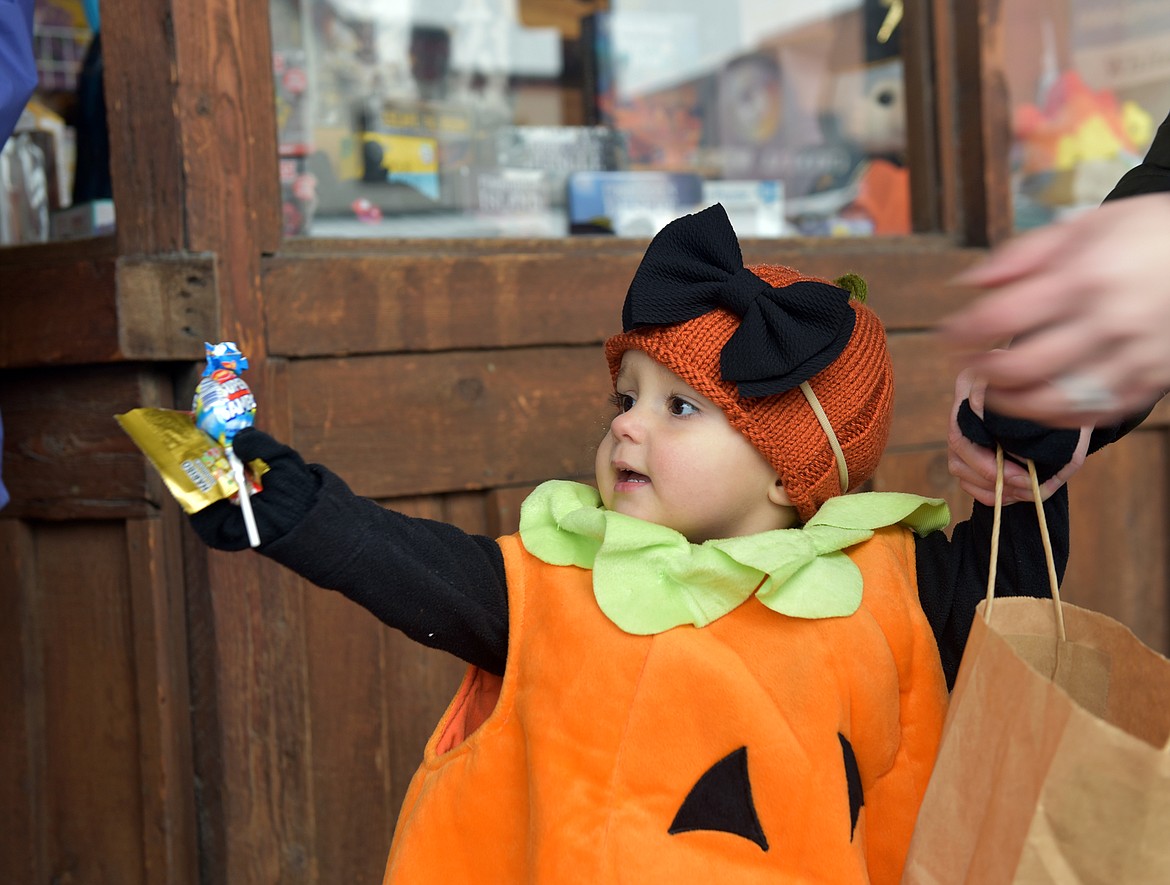 Ember, a pumpkin, trick or treats on Central Ave on Oct. 31. (Kelsey Evans/Whitefish Pilot)