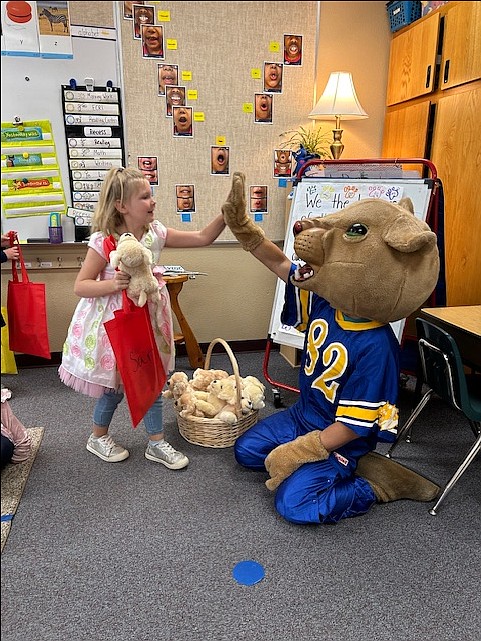 Hope Elementary first grader Sarah Service celebrates during puppy adoption day with Wampy, the Clark Fork Jr/Sr High School mascot.