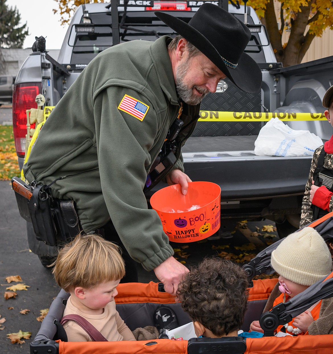 Sanders County Sheriff Shawn Fielders passes out candy at the Plains School Trunk or Treat event. (Tracy Scott/Valley Press)