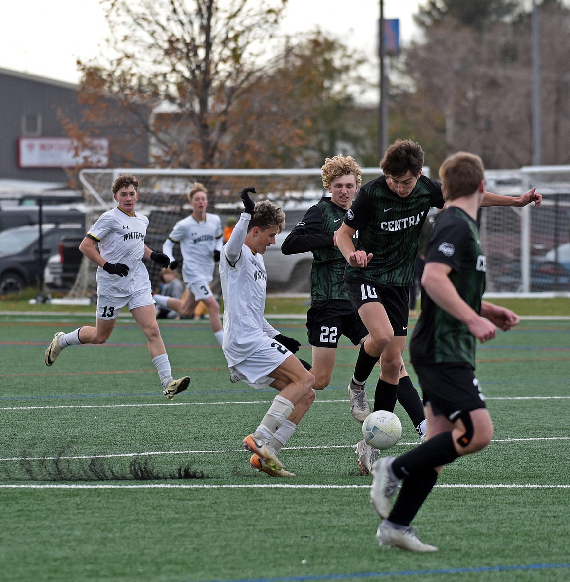 Logan Bingham kicks up the turf as he moves through midfield on Saturday. (Julie Engler/Whitefish Pilot)