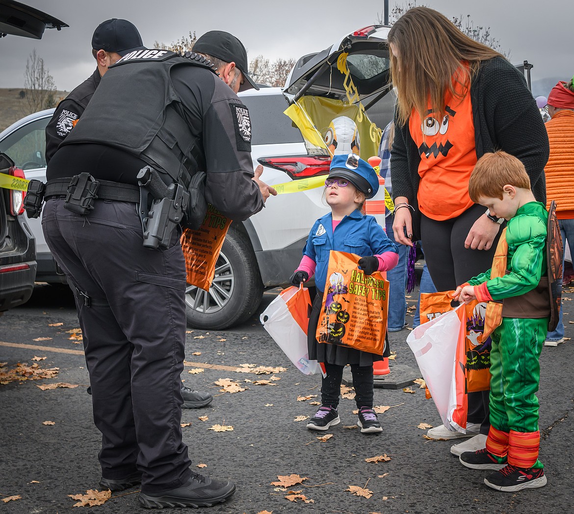 Plains Police Officer Rob Geenen discusses police techniques with young officer Payton Brown at the Plains School Trunk or Treat. (Tracy Scott/Valley Press)