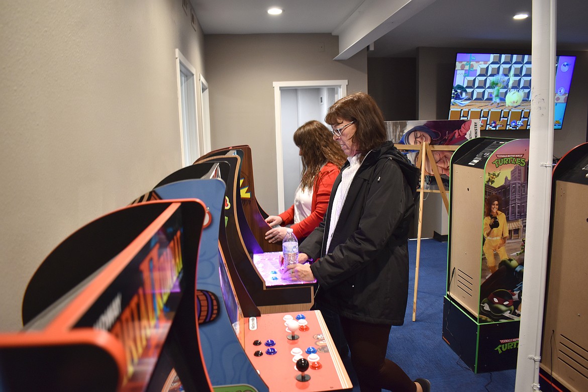 Crysie Kluth, right, plays a retro game of Frogger while Michaelle Boetger plays Pac-Man at Youth Dynamics’ recently remodeled loft Tuesday.  Both said the games are more difficult than they remembered.