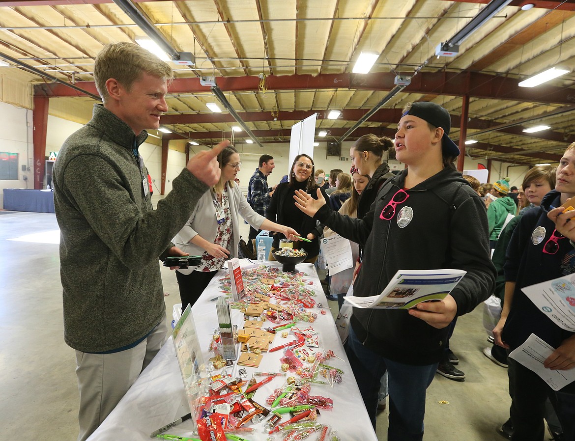 Northwest Specialty Hospital marketing and creative manager Trent Emerson engages Wednesday morning with Timberlake Middle School eighth grader Bradley LaFortune during Unlock Your Future North Idaho at the Kootenai County Fairgrounds. About 1,100 students and 45 vendors participated in the inaugural event.