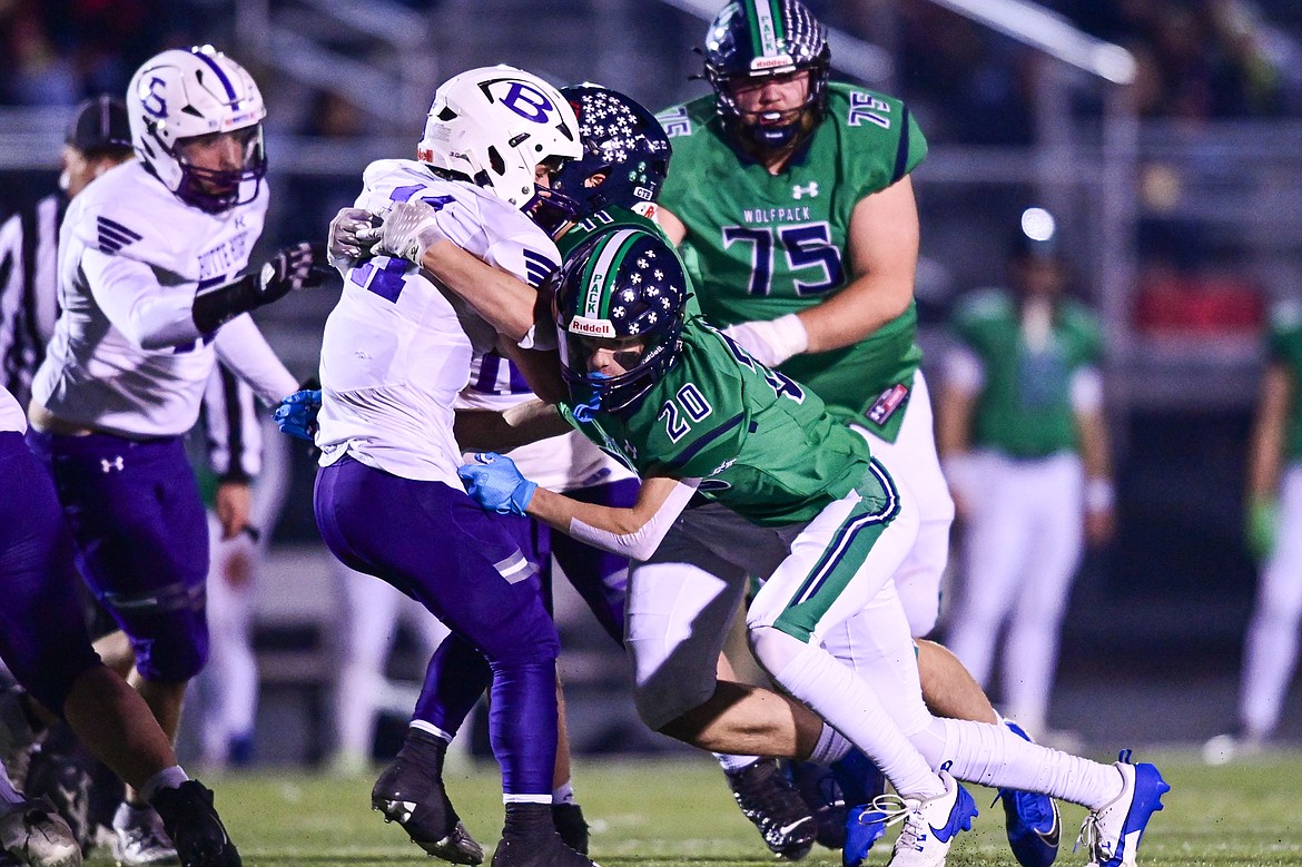 Glacier defenders Grady Robinson (20) and Asher Knopik (11, back) stop a run by Butte running back Karson Pumnea (11) in the first quarter during a Class AA playoff game at Legends Stadium on Friday, Nov. 8. (Casey Kreider/Daily Inter Lake)