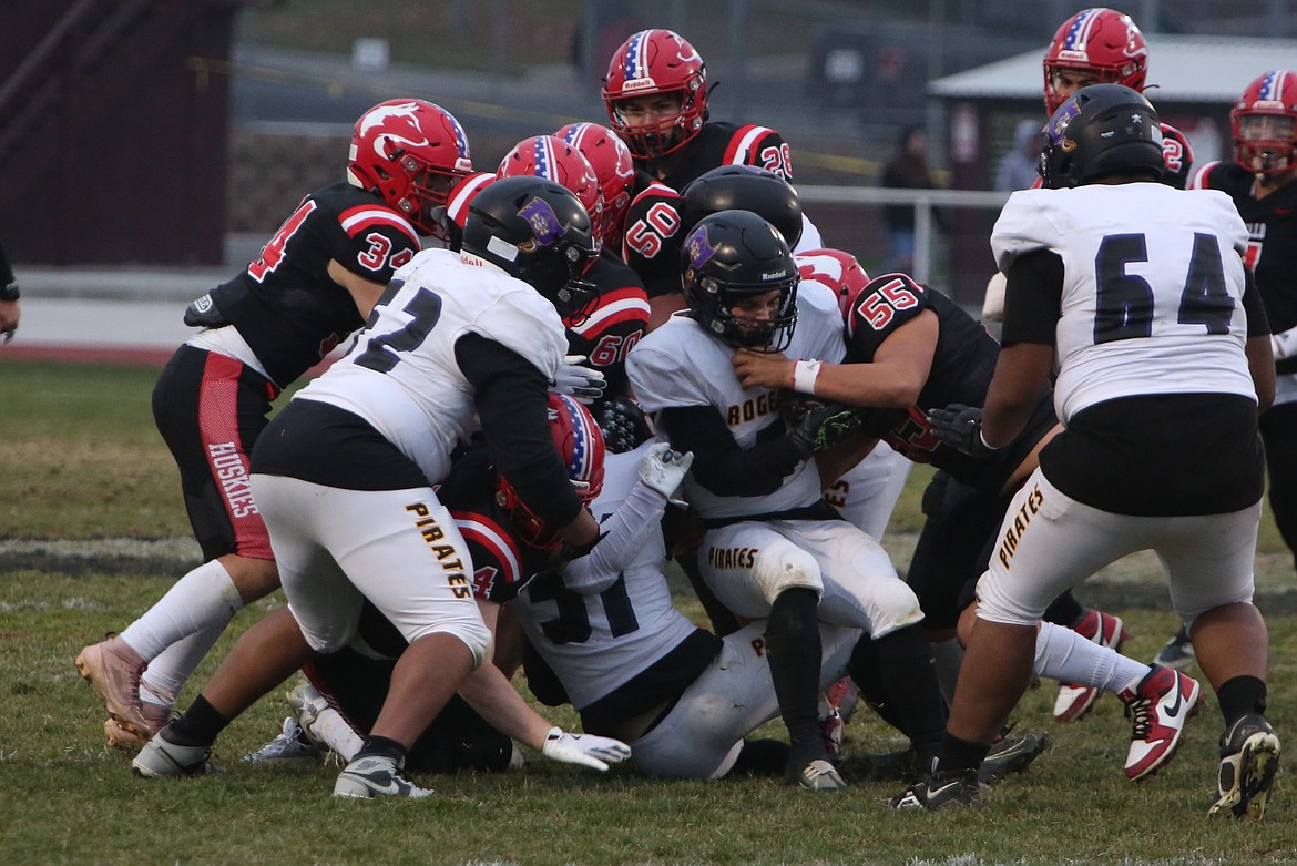 Othello defenders group up for a tackle during the second half against Rogers (Spokane) on Saturday afternoon. The Huskies held the Pirates to a season-low seven points.