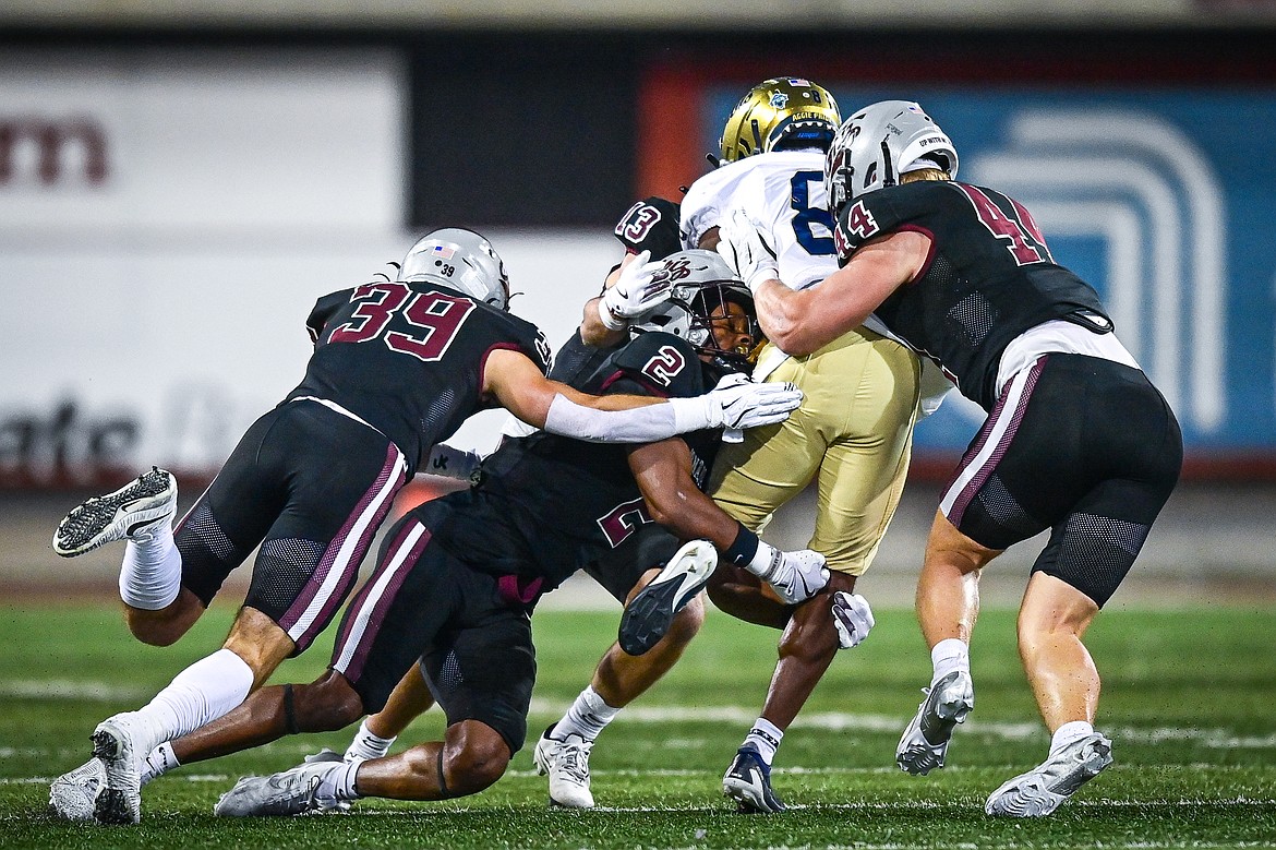 Grizzlies defenders tackle UC Davis wide receiver Samuel Gbato Jr. (8) in the first half at Washington-Grizzly Stadium on Saturday, Nov. 9. (Casey Kreider/Daily Inter Lake)