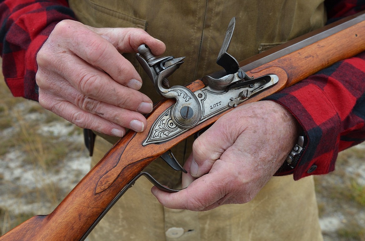 Robert Saint-Louis displays the firing mechanism on a flintlock rifle during the Turkey Shoot held last Saturday at Fort Connah. (Kristi Niemeyer/Leader)