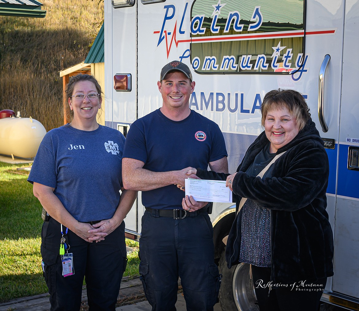 Plains Community Ambulance members Seth Gibbs and Jen Fratzke accept a donation from Clark Fork Valley Elks Lodge member Margaret Wakefield. (Tracy Scott/Valley Press)