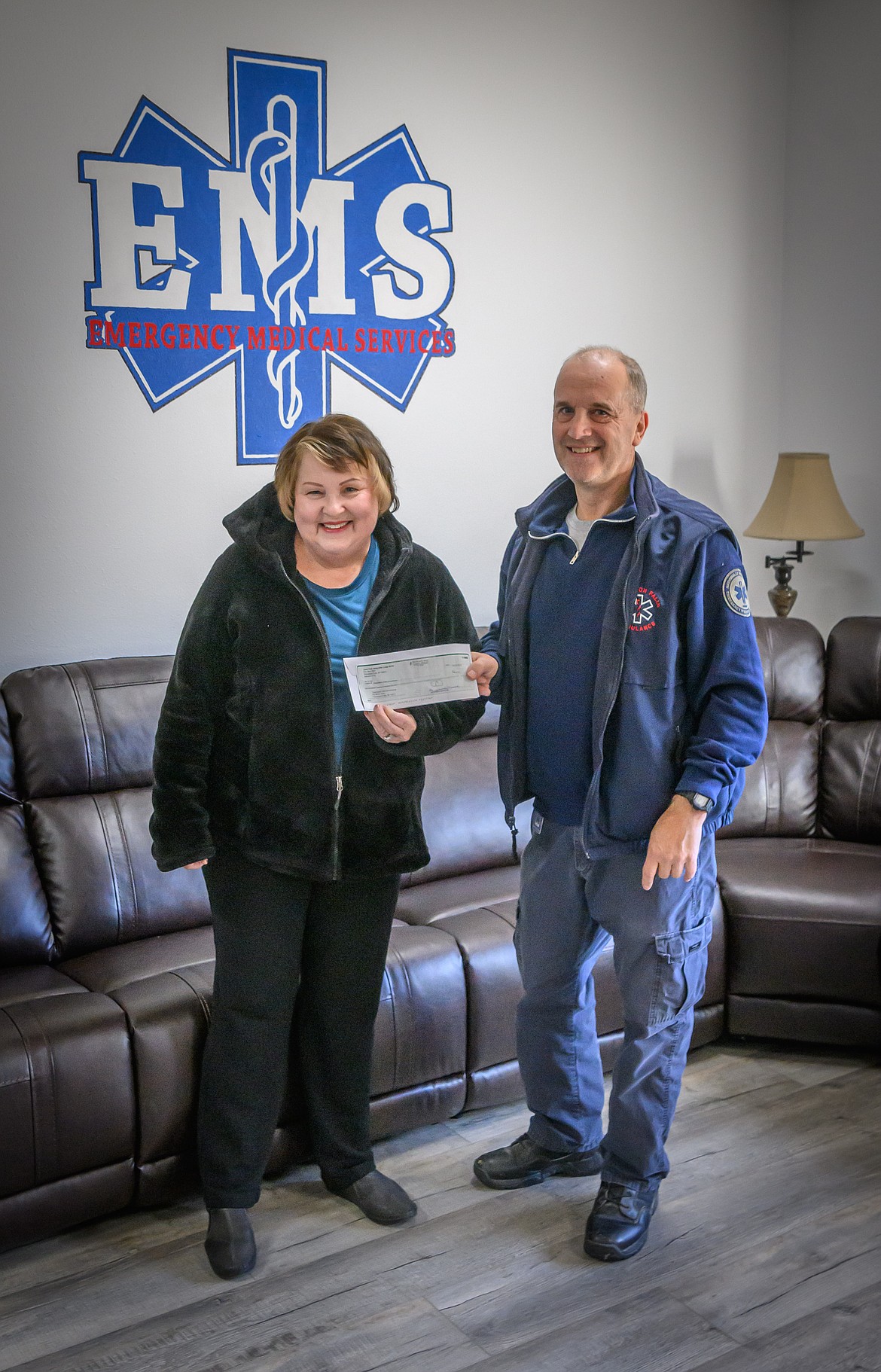 Thompson Fall Ambulance EMT Pete Milne accepts a donation Check from Clark Fork Valley Elks Lodge member Margaret Wakefield. (Tracy Scott/Valley Press)