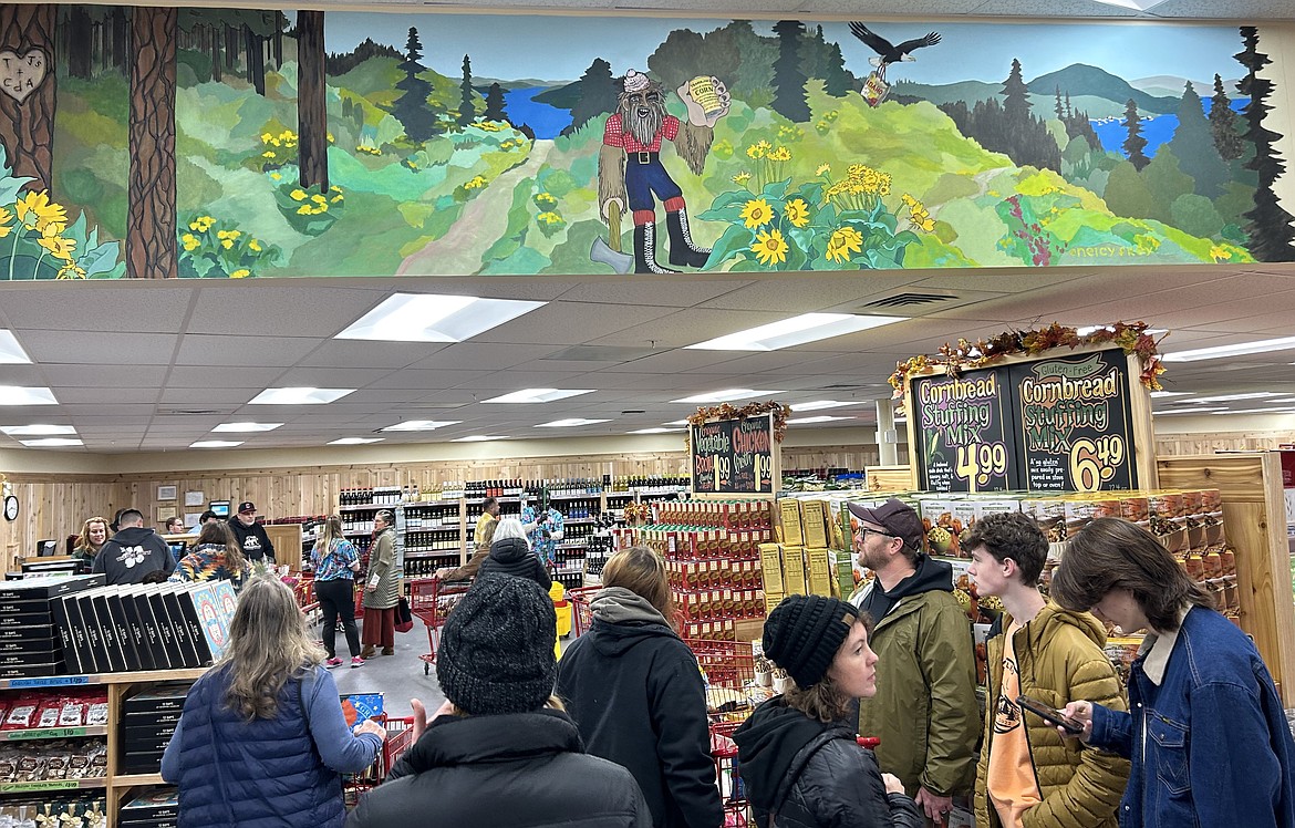 Customers stand below artwork in the Trader Joe's store Tuesday.