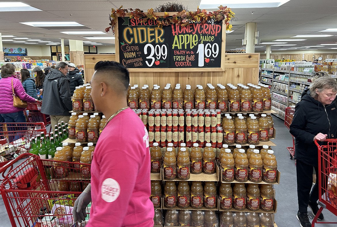 Customers pass by a display of apple cider at Trader Joe's on Tuesday.