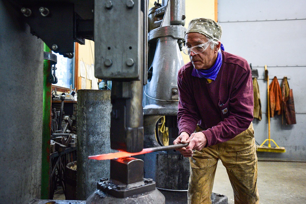 Jeffrey Funk forges a piece of steel at a Chambersburg power hammer in his workshop at the New Agrarian School in Bigfork on Tuesday, Nov. 12. (Casey Kreider/Daily Inter Lake)