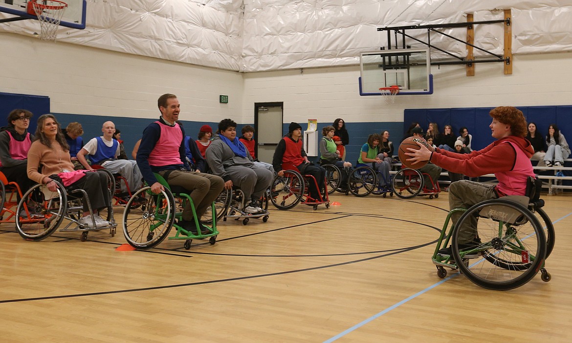 New Vision High School freshman Ethan Barton, right, wheels toward Principal Thomas Staples during a wheelchair basketball exercise Wednesday at the Post Falls Boys and Girls Club.