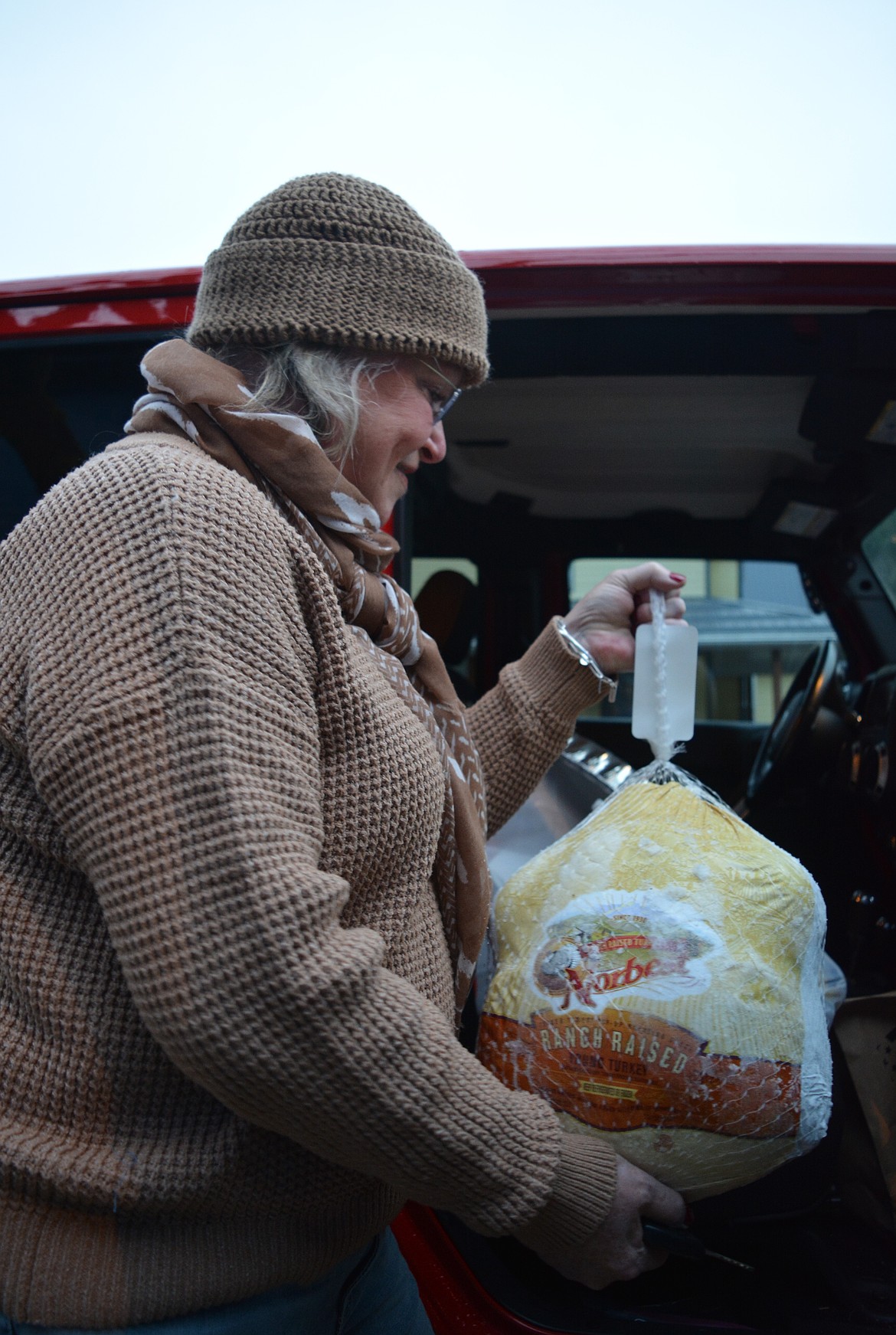 Cindy Lien loads a frozen turkey for Thanksgiving 2023 into her car for deliveries for the Wallace Elks Thanksgiving deliveries. Lien is a board member at the Wallace Elks, which will be hosting a free Thanksgiving dinner from 1-5 p.m. Thursday Nov. 28.