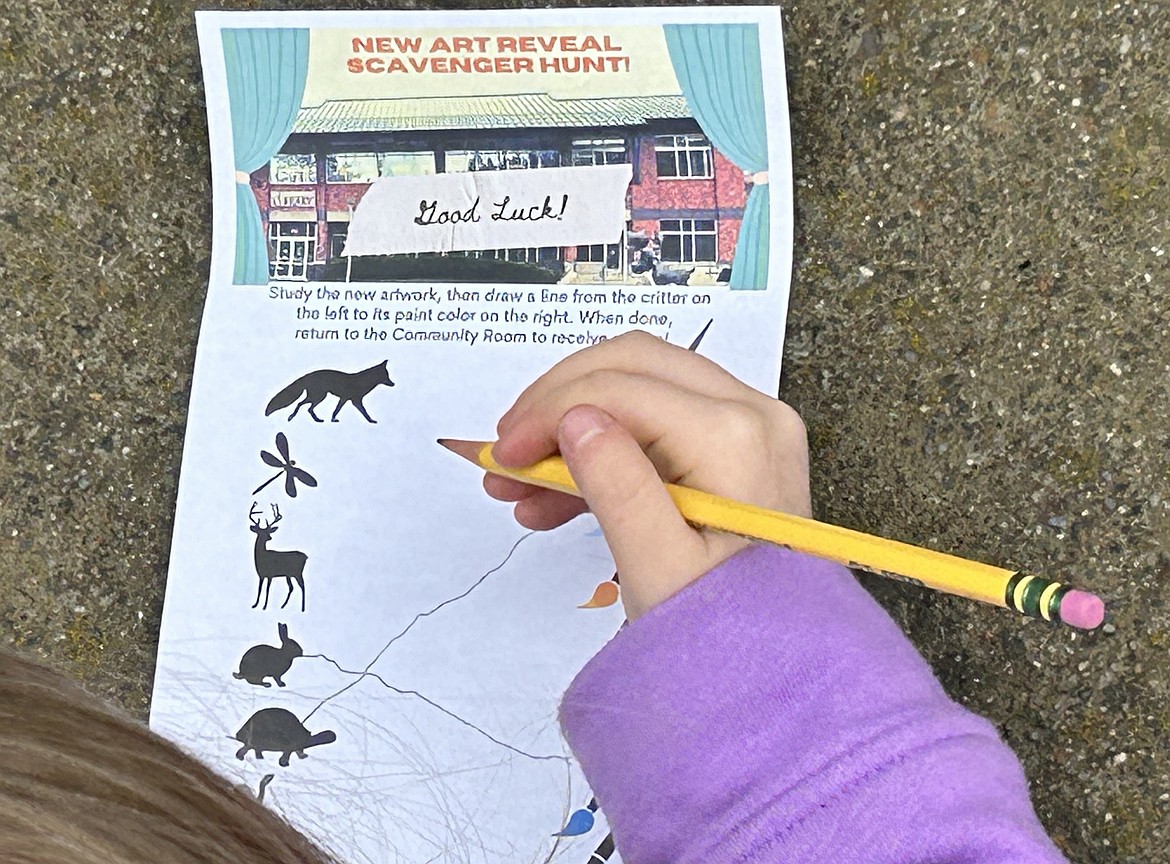 A child connects animals with colors outside the Coeur d'Alene Public Library during an unveiling of artwork on Thursday.