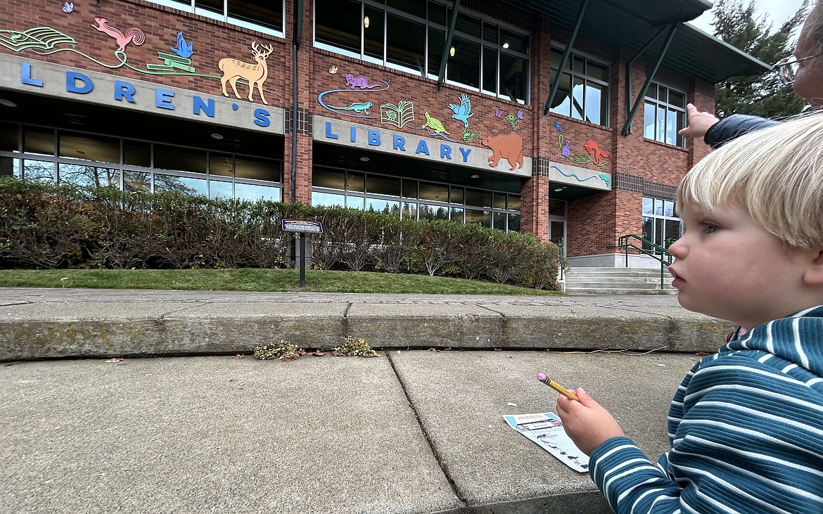 June Gittens looks at the artwork on the brick wall outside the Coeur d'Alene children's library on Thursday