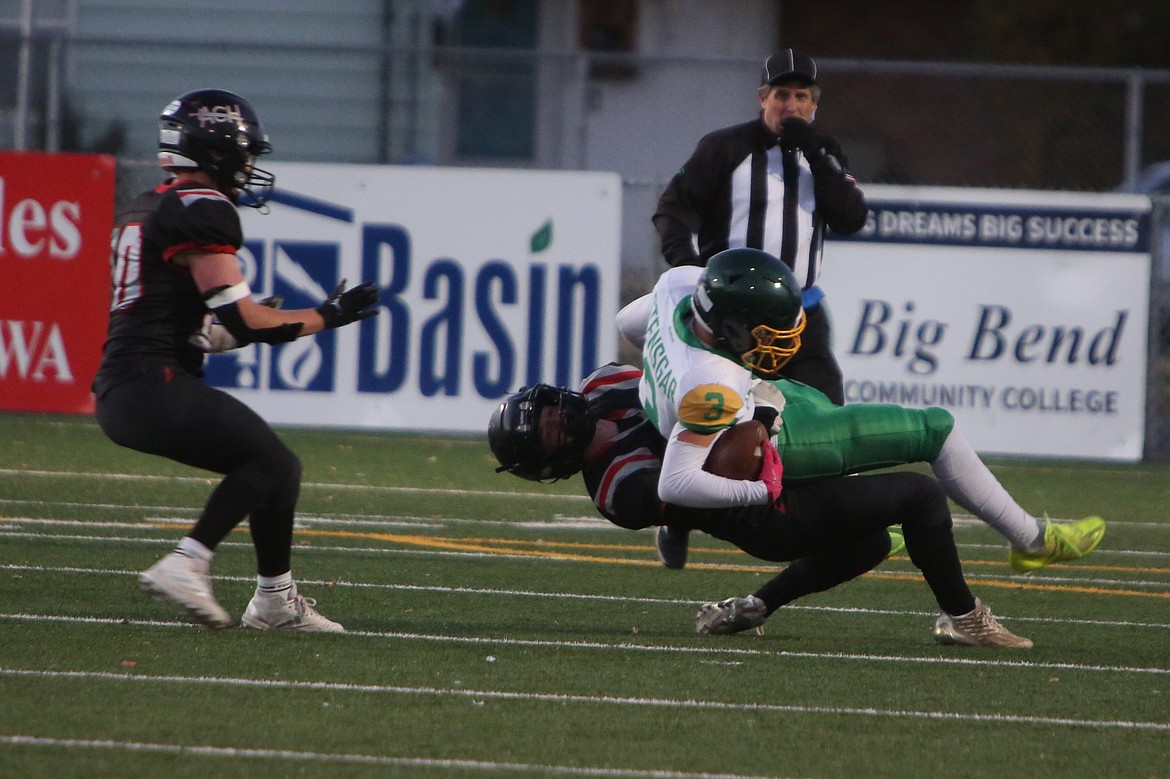 Almira/Coulee-Hartline junior Harvest Parrish, bottom right, tackles an Inchelium receiver during the first quarter of Friday’s 48-0 win over the Hornets.