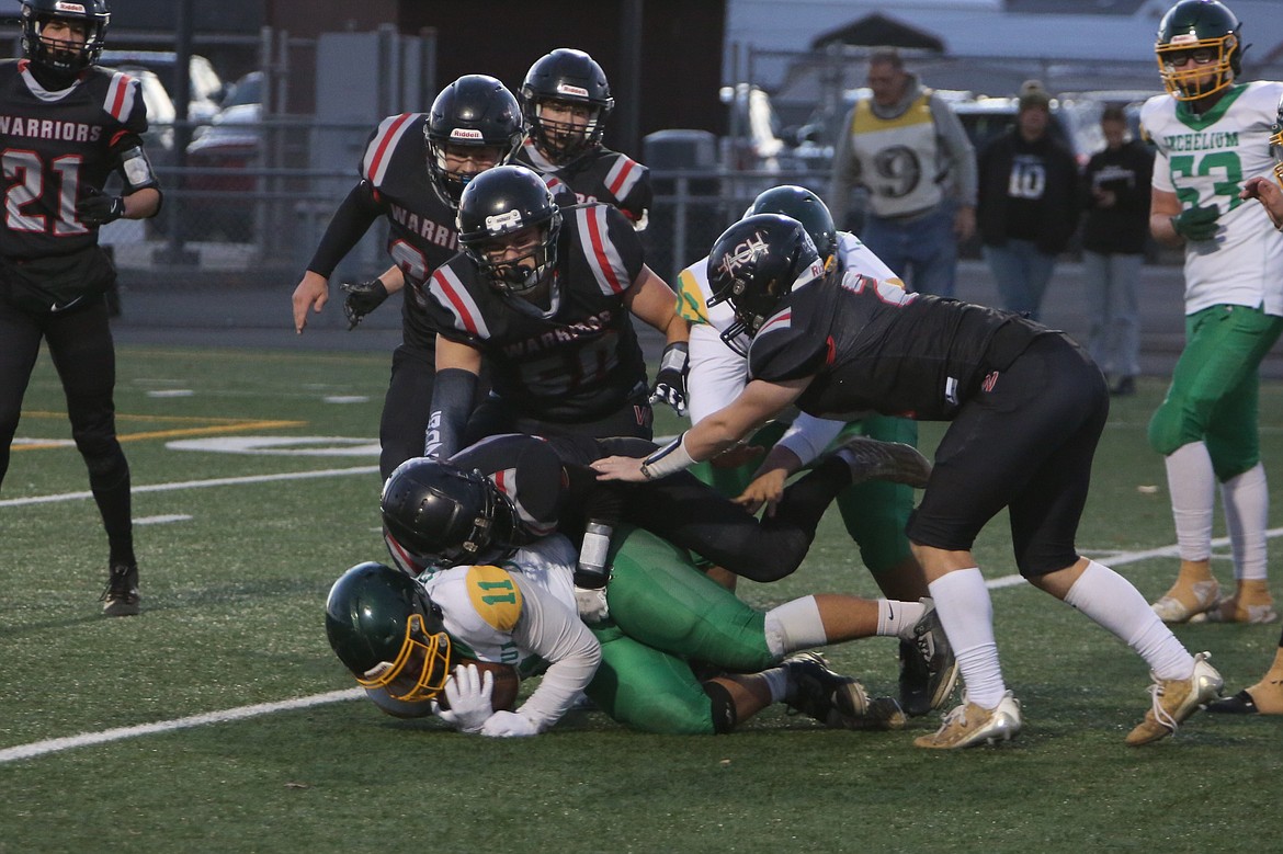 A group of Almira/Coulee-Hartline defenders combine for a tackle during the second quarter against Inchelium on Friday. The Warrior defense forced its first shutout of the season on Friday night at Lions Field in Moses Lake.