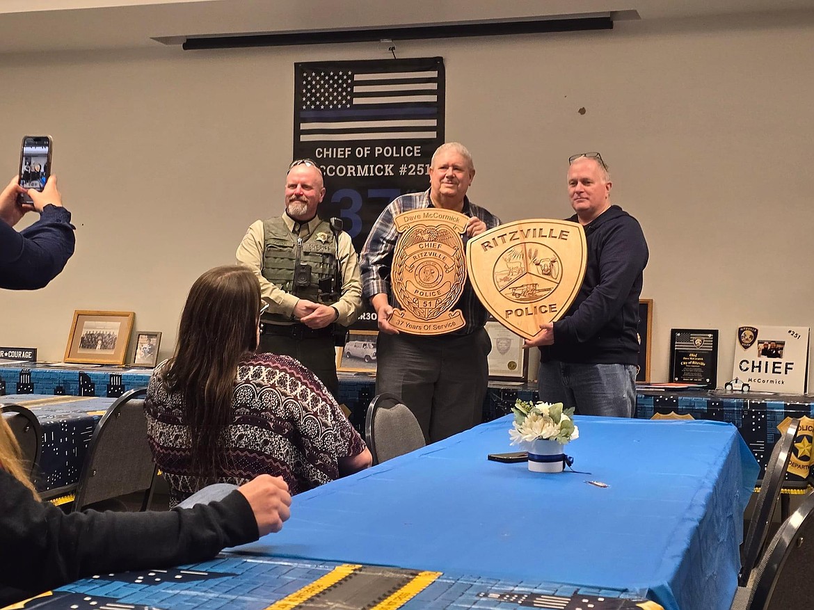 Deputy Mark Cameron and retired Officer Tom Gracie presented newly-retired Chief Dave McCormick with retirement gifts at his going-away shindig Friday. McCormic was with Ritzville PD for 32 years.