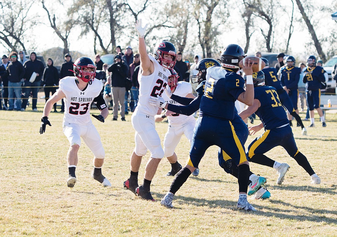 Senior John Waterbury (23) and Weston Slonaker (22) put pressure on Box Elder quarterback Taurie Stiffarm-Rossette during their playoff semifinal Saturday in Box Elder.  (Photo by Teresa Waterbury)