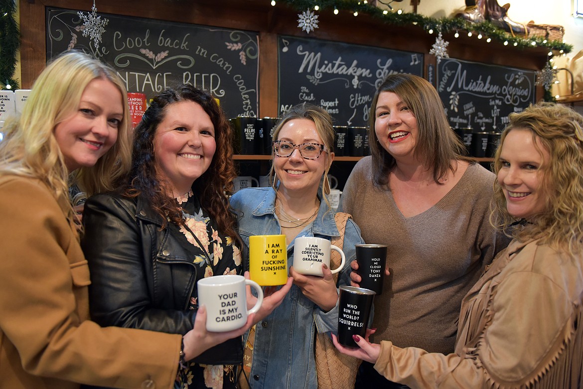 Friends laugh at mugs that fit the theme of the night at Meriwether. (Kelsey Evans/Whitefish Pilot)