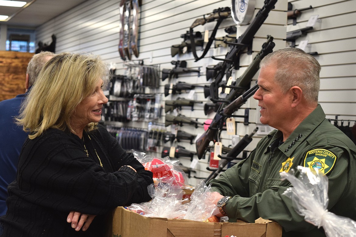 3rd Place Marketplace executive director Leslie Orth (left) chats with Kootenai County Sheriff Bob Norris during Tuesday's food drive in Post Falls.