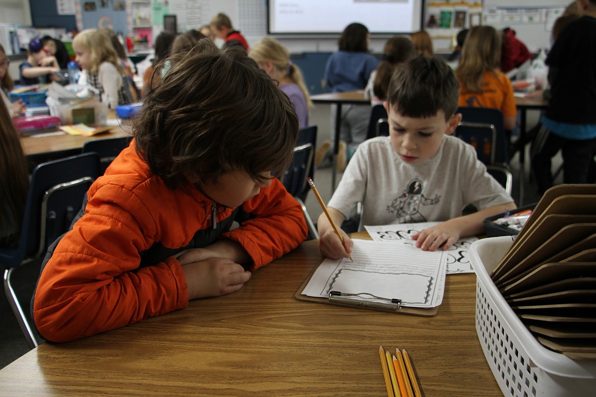 Second and fourth graders at Farmin Stidwell Elementary draft letters of kindness as part of a project that will deliver 210 fleece blankets to community members in need.