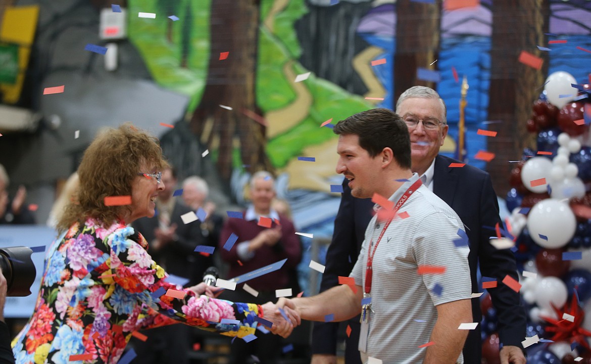 Confetti flies as Marcus Ross shakes Milken Educator Awards Senior Vice President Jane Foley's hand in disbelief Wednesday morning after learning he won the award plus a $25,000 cash prize. The celebration was attended by several dignitaries, including Idaho Lt. Gov. Scott Bedke, right.