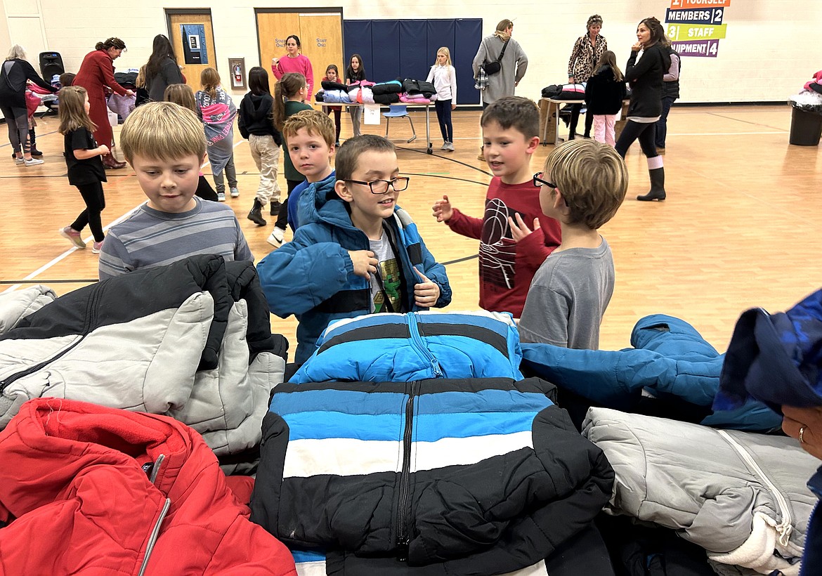 Kids check out piles of coats in the gym at the Kootenai County Boys and Girls Club in Coeur d'Alene on Thursday.