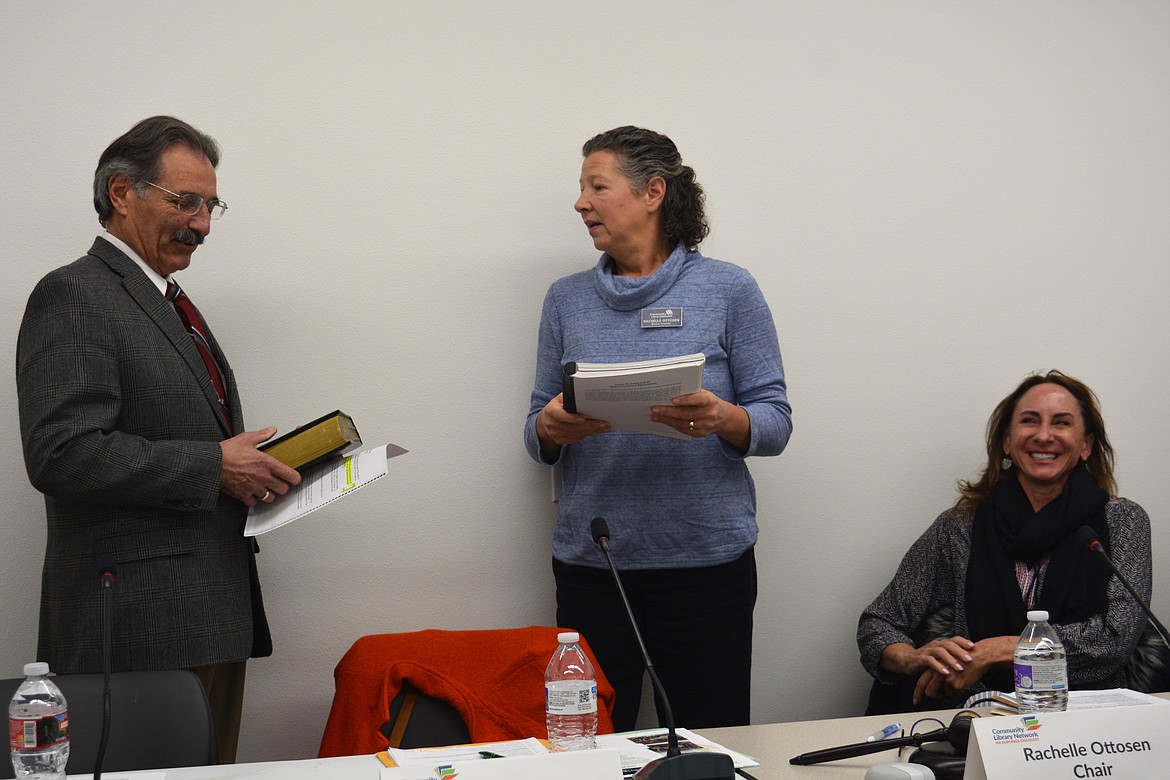 Tony Ambrosetti is sworn onto the Community Library Network board Thursday by Chair Rachelle Ottosen as Trustee Vanessa Robinson looks on.