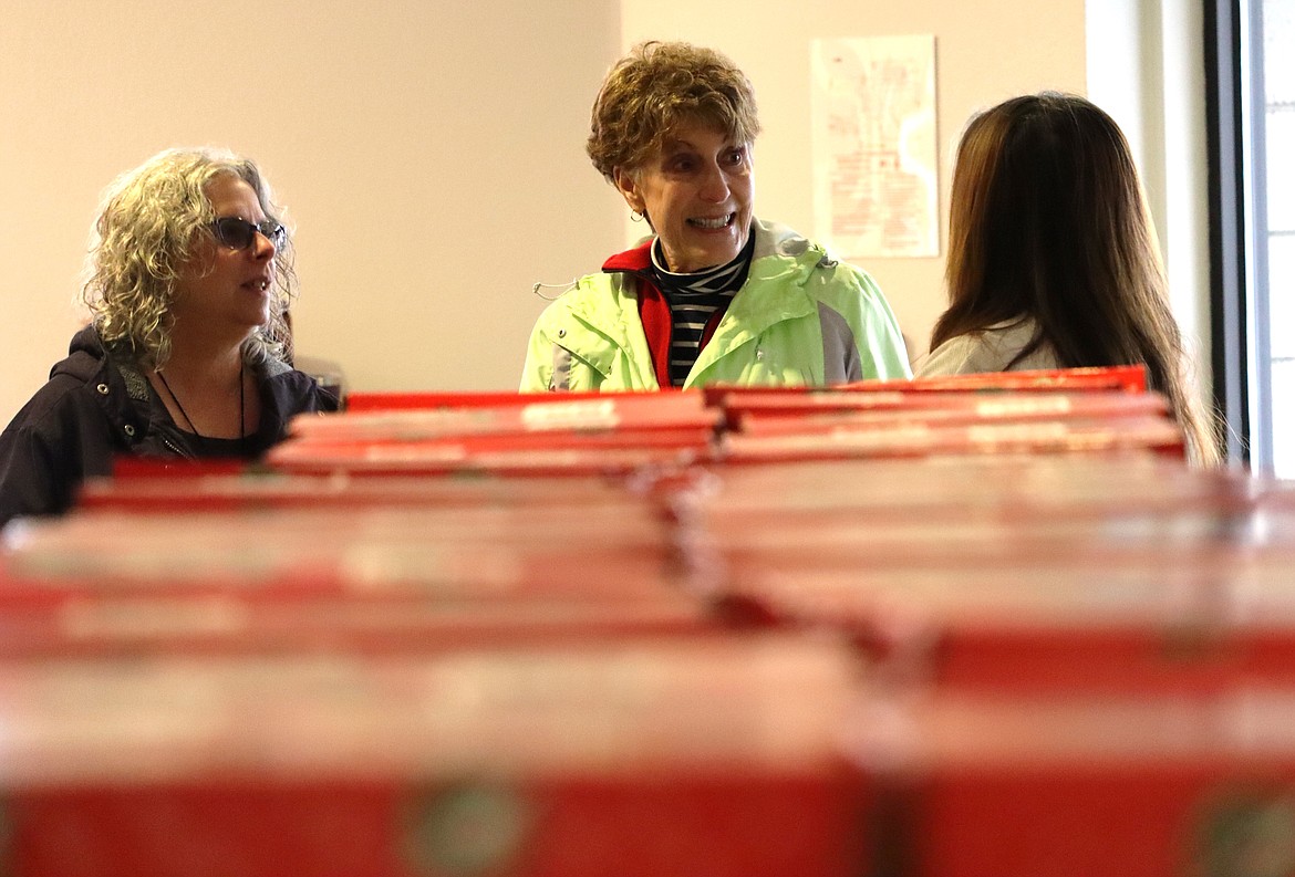 Chris Maiani, center, chats with others after delivering shoeboxes of gifts for Operation Christmas Child at Anthem Church on Thursday.