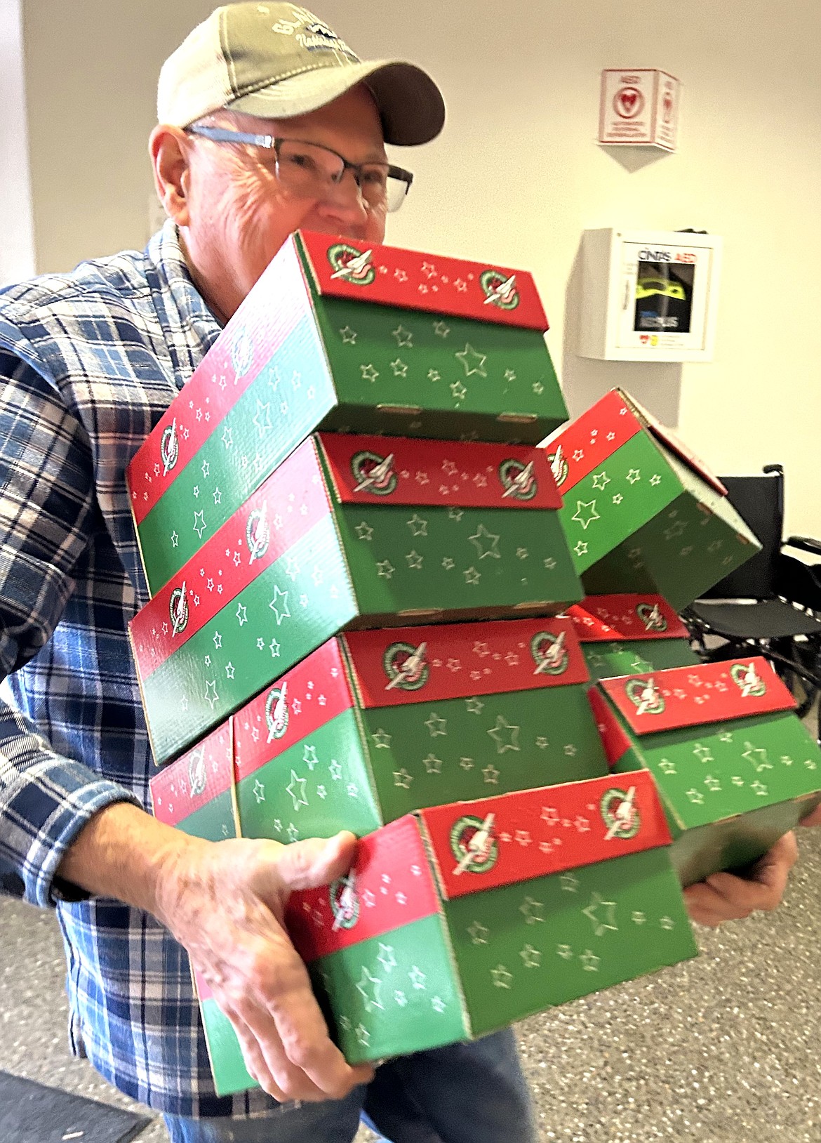 Craig Hartwig carries Operation Christmas Child shoeboxes at Anthem Church on Thursday.