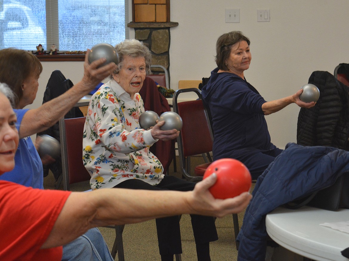 Betty Reed, 1012, and Cindy Oberholtzer work their wrists and arms to increase mobility using small exercise balls. Members of the Hayden Senior Center surprised Reed on Friday with the gift of a butterfly blanket to keep her warm and cozy.