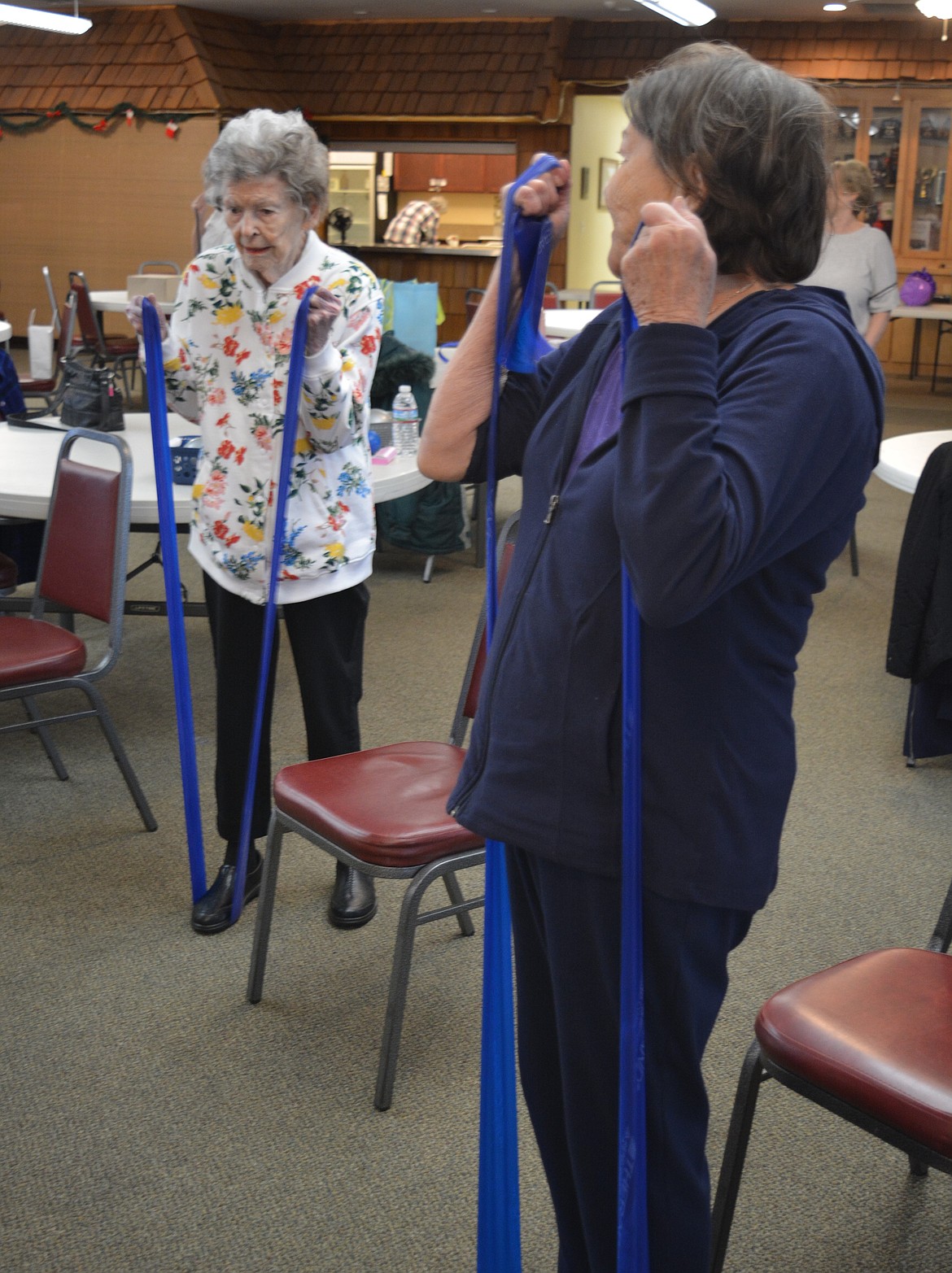 Betty Reed, 102, and her daughter, Cindy Oberholtzer, stretch out elastic bands as part of a Fit and Fall Proof class Friday at the Hayden Senior Center.