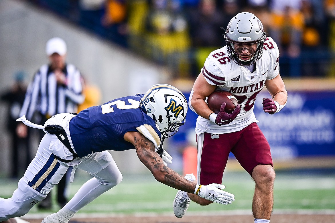 Grizzlies running back Nick Ostmo (26) breaks a tackle by Bobcats safety Dru Polidore (2) on a run in the first quarter during the 123rd Brawl of the Wild at Bobcat Stadium on Saturday, Nov. 23. (Casey Kreider/Daily Inter Lake)