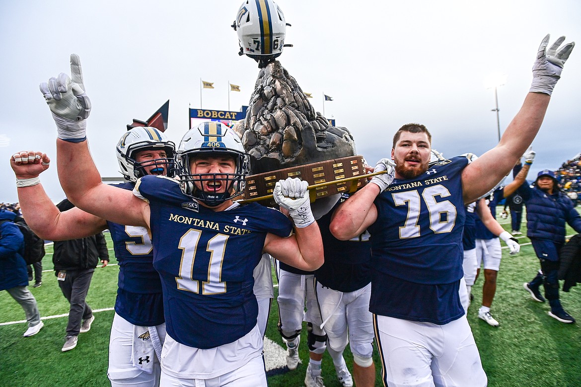 The Bobcats celebrate with the Land Grant Trophy after a 34-11 win over the Griz in the 123rd Brawl of the Wild at Bobcat Stadium on Saturday, Nov. 23. (Casey Kreider/Daily Inter Lake)