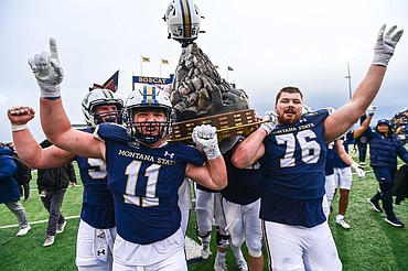 The Bobcats celebrate with the Great Divide Trophy after a 34-11 win over the Griz in the 123rd Brawl of the Wild at Bobcat Stadium on Saturday, Nov. 23. (Casey Kreider/Daily Inter Lake) <a href="https://dailyinterlake.dotphoto.com/">Click here to order photo reprints.</a>