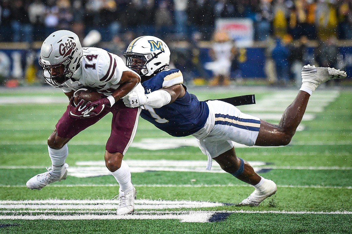 Grizzlies wide receiver Aaron Fontes (14) breaks a tackle by Bobcats defensive back Andrew Powdrell (14) on a reception in the fourth quarter during the 123rd Brawl of the Wild at Bobcat Stadium on Saturday, Nov. 23. (Casey Kreider/Daily Inter Lake)