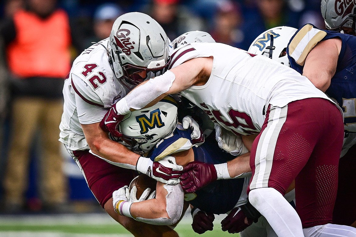 Grizzlies defenders Riley Wilson (42) and Garrett Hustedt (56) stop a run by Bobcats running back Adam Jones (23) in the third quarter during the 123rd Brawl of the Wild at Bobcat Stadium on Saturday, Nov. 23. (Casey Kreider/Daily Inter Lake)