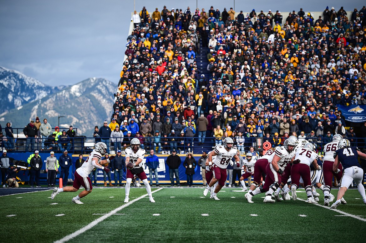 Grizzlies quarterback Logan Fife (12) hands off to running back Nick Ostmo (26) in the second quarter against the Bobcats during the 123rd Brawl of the Wild at Bobcat Stadium on Saturday, Nov. 23. (Casey Kreider/Daily Inter Lake)