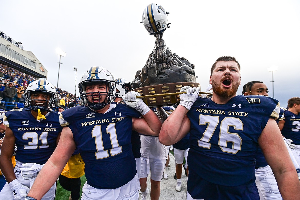 The Bobcats celebrate with the Land Grant Trophy after a 34-11 win over the Griz in the 123rd Brawl of the Wild at Bobcat Stadium on Saturday, Nov. 23. (Casey Kreider/Daily Inter Lake)