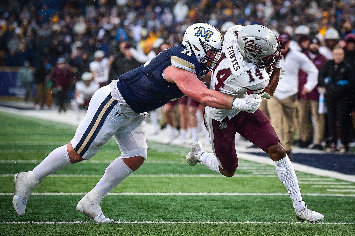 Grizzlies wide receiver Aaron Fontes (14) is brought down by Bobcats defensive end Kenneth Eiden IV (11) on a reception in the fourth quarter during the 123rd Brawl of the Wild at Bobcat Stadium on Saturday, Nov. 23. (Casey Kreider/Daily Inter Lake)